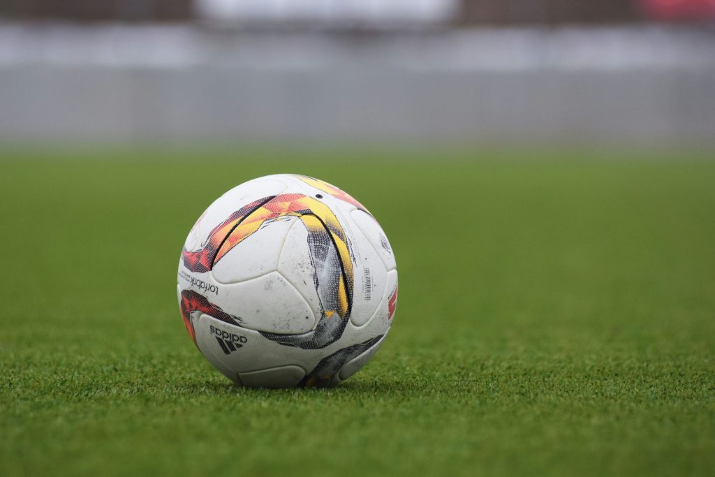 Weißer und grauer Adidas-Fußball auf Rasengras
